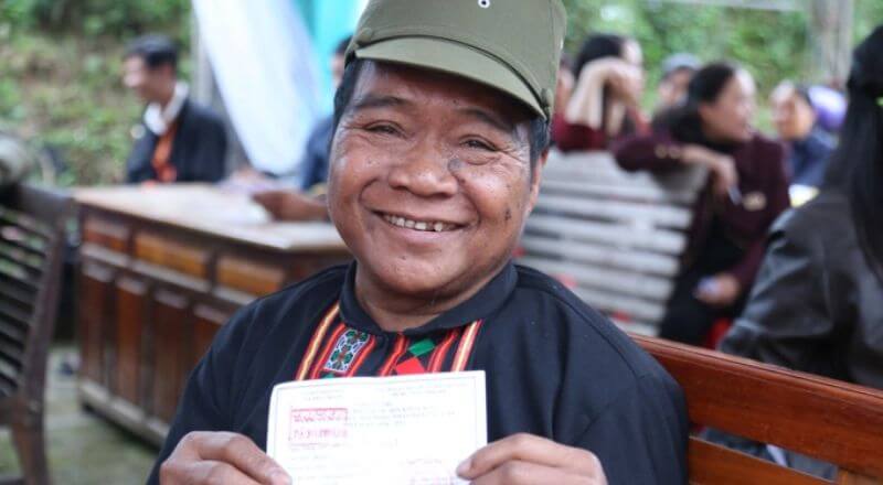 Cử tri người Chứt đang tươi cười giơ thẻ cử tri sau khi bỏ phiếu