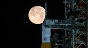 Mặt Trăng hiện ra phía sau tổ hợp tên lửa SLS và tàu vũ trụ Orion của NASA tại Trung tâm Vũ trụ Kennedy