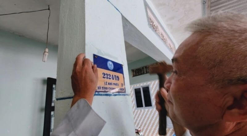 Ông Hậu đang gắn số nhà mới do UBND xã Bình Chánh cấp, thay thế cho bảng số cũ A12/36 vốn không ghi tên đường