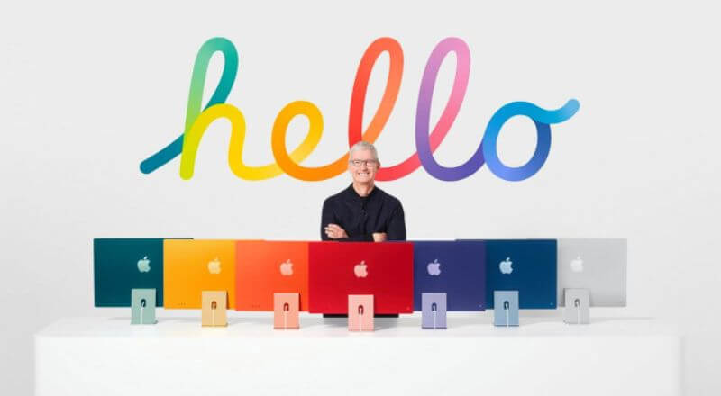 Tim Cook tạo dáng bên cạnh dàn máy tính iMac rực rỡ với nhiều màu sắc khác nhau.